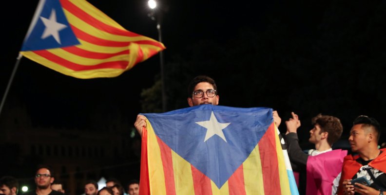 A man holds an Estelada (Catalan separatist flag) as people gather at Plaza Catalunya after voting ended for the banned independence referendum, in Barcelona A man holds an Estelada (Catalan separatist flag) as people gather at Plaza Catalunya after voting ended for the banned independence referendum, in Barcelona