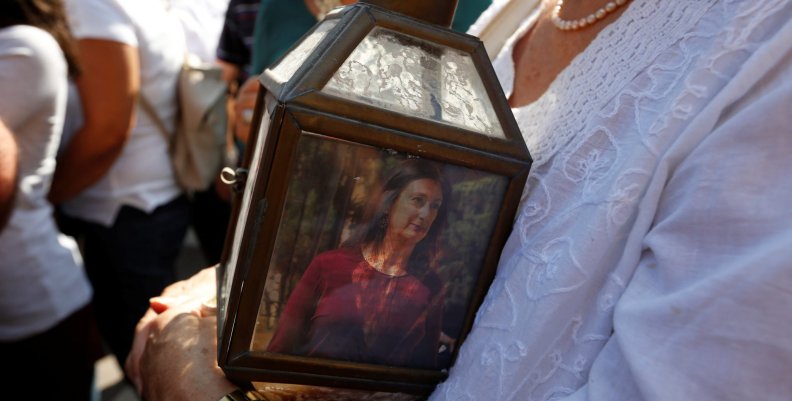 A woman holds a lantern with a picture of investigative journalist Daphne Caruana Galizia, who was assassinated in a car bomb attack, during a protest outside the law courts in Valletta A woman holds a lantern with a picture of investigative journalist Daphne Caruana Galizia, who was assassinated in a car bomb attack, during a protest outside the law courts in Valletta