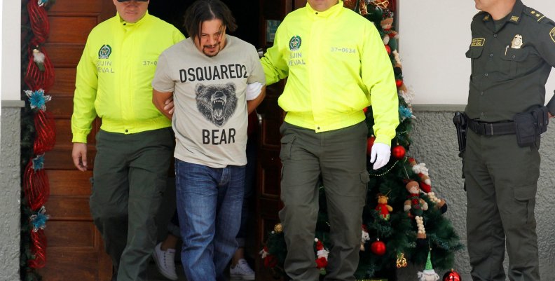 Juan Carlos Mesa Vallejo, also known as "Tom", is escorted by police officers during a press presentation at the Police headquarters in Medellin Juan Carlos Mesa Vallejo, also known as "Tom", is escorted by police officers during a press presentation at the Police headquarters in Medellin