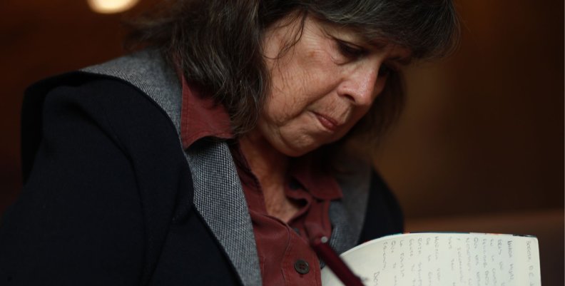 Laura Restrepo Una mujer de cabello negro firmando un libro