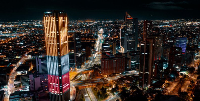 Bogotá Vista panorámica de Bogotá de noche: se ve un rascacielos con la bandera de Colombia