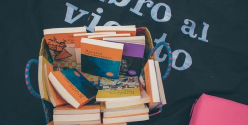Libro al viento Imagen de libros apilados sobre un fondo azul rey