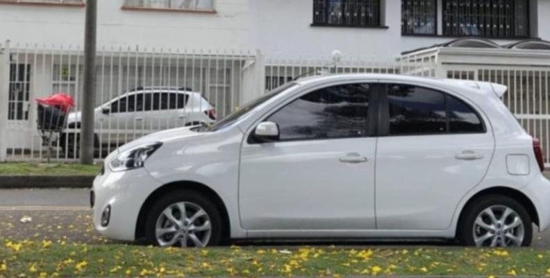 Carro Automóvil blanco parqueado en una acera