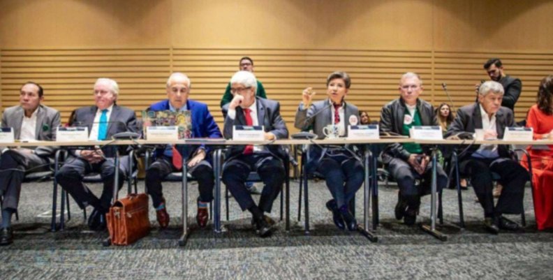 Claudia López sentada en una mesa junto con su gabinete