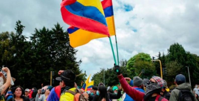 Multitud de personas. Uno de los manifestantes hondea una bandera de Colombia