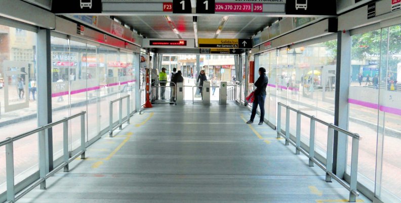 TransMilenio Estación de transMilenio por dentro un pacillo con piso metálico y puertas de cristal a los lados