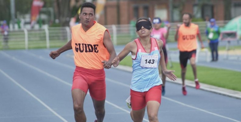 Juegos Parapanamericanos Una atleta y su guía corriendo en una pista de atletismo