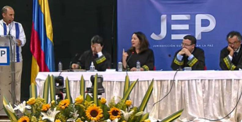 Funcionarios de la JEP sentados en una mesa blanca