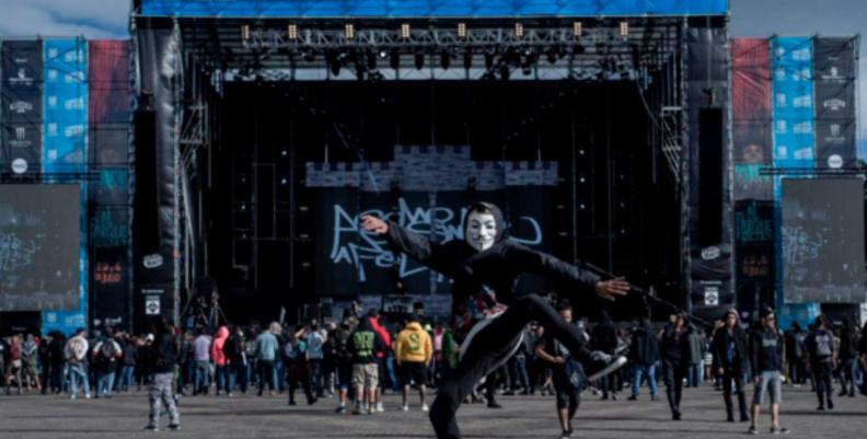 Hombre con una máscara de anonimus en medio de una multitud de Rock al Parque