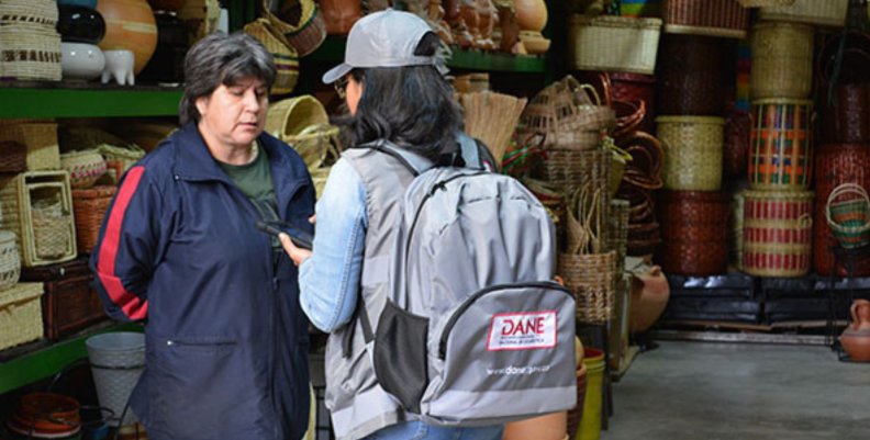 Censo económico Mujer con chaqueta gris encuestando a una señora