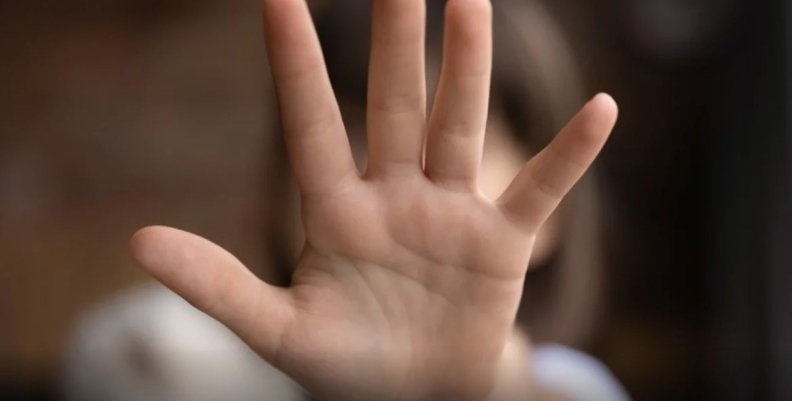 Violencia contra la niñez Niña poniendo su mano al frente para tapar su cara