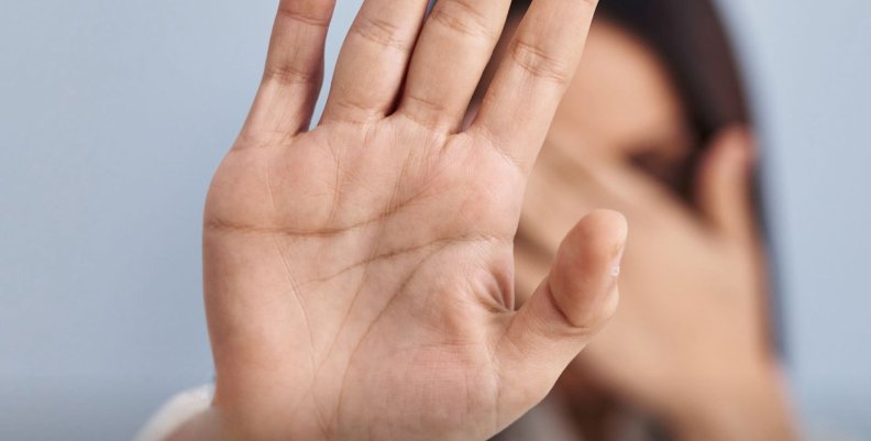 Mujer cubriéndose la cara con su mano