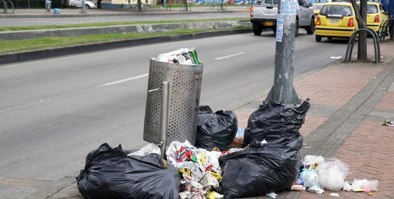 Basuras en Bogotá Un bote de basura desbordado, con basura alrededor