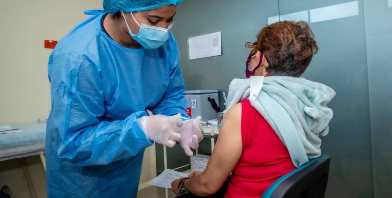 Fiebre amarilla Mujer vacunando a otra mujer de la tercera edad
