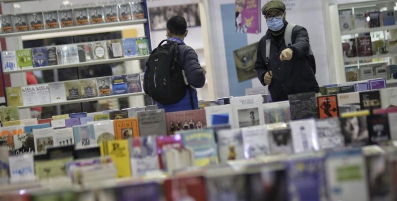 Feria del Libro de Bogotá Dos personas caminando por pasillos llenos de libros