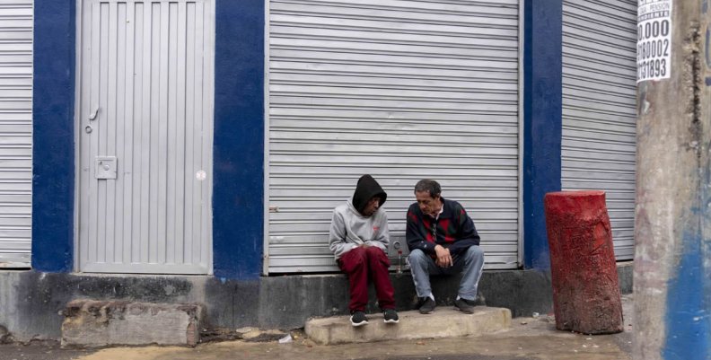 Habitantes de calle Dos hombres sentados en un andén