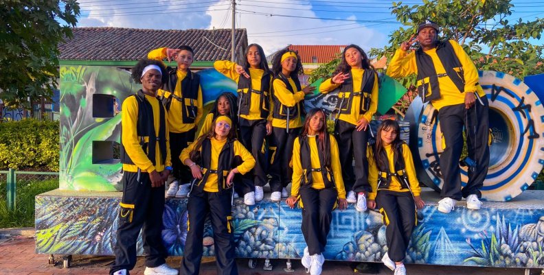 Ciudad Bolívar Jóvenes con uniforme amarillo sobre un letrero