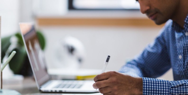 Facturación electrónica en Colombia Hombre sentado frente a un pc portátil