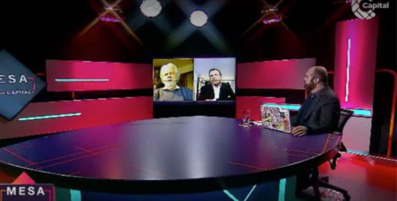 Santiago Rivas sentado frente a una mesa en su espacio televisivo de Mesa Capital.