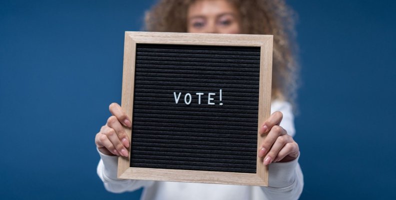 Voto de los jóvenes en eureka Tu Canal Niño sostiene un tablero con la palabra Voto
