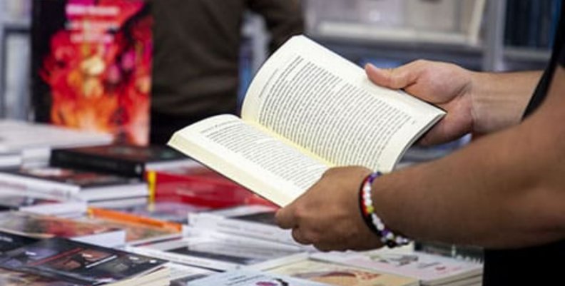 Libros Persona con un libro en las manos en la Feria del Libro