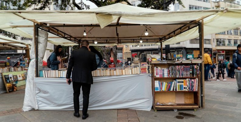 Feria Popular del Libro Hombre viendo un puesto con muchos libros en una Feria Popular de Bogotá