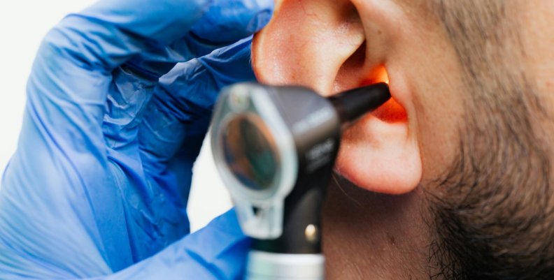 Examen de oído Hombre haciéndose un examen de oído