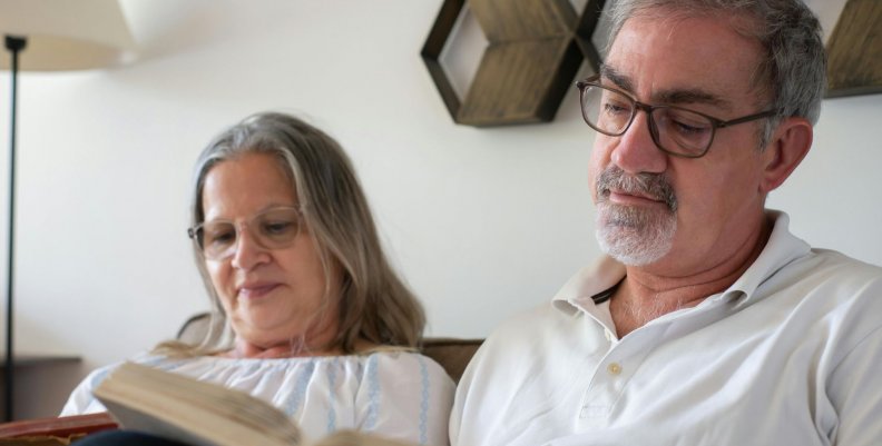 Ancianos lectores Dos adultos mayores leyendo libros en un sillón