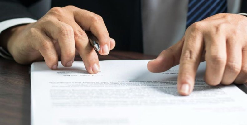 Contratos Hombre con una hoja sobre la mesa a punto de firmar