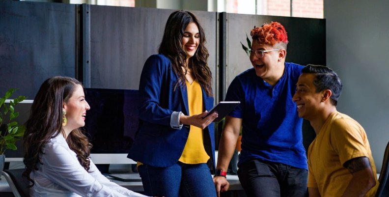 Inteligencia emocional Compañeros y compañeras de trabajo jóvenes hablando durante un receso laboral