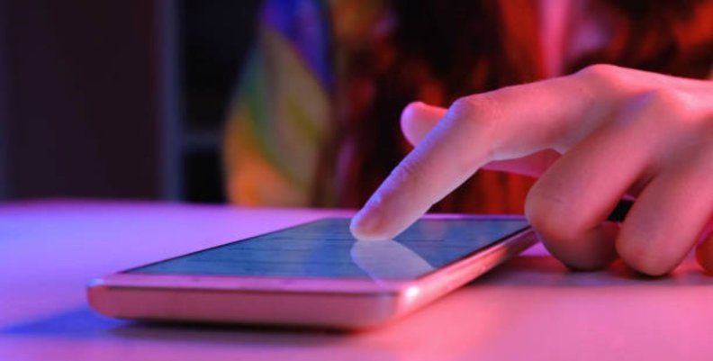 Joven es acosada y amenazada por redes sociales: la Fiscalía aún no responde ante las denuncias Mano de una persona usando su celular