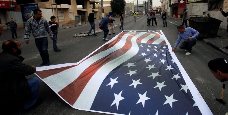 Palestinian demonstrators place on the ground a representation of a U.S. flag during a protest in the West Bank city of Bethlehem Palestinian demonstrators place on the ground a representation of a U.S. flag during a protest in the West Bank city of Bethlehem