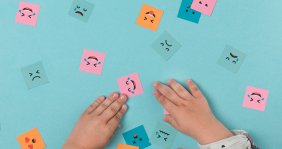 Niño jugando con cuadros con caras dibujadas - Imagen por Freepik