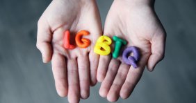 Manos con la palabra LGBTQ hecha de plastilina
