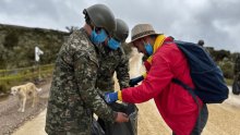 Dos militares sosteniendo una bolsa de basura 