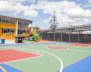 Patio principal de un colegio de Bogotá con una cancha de microfútbol pintada de verde, rojo y azul.