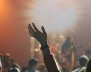 Mujer alzando la mano en un concierto 