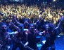 Una banda posando detrás de un público lleno de personas