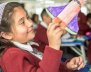 Niña jugando con una nave espacial de papel