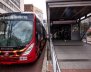 Bus de TransMilenio, color rojo, rodando por la calle 
