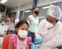 Enfermera vacunando a una niña. Ambas portan tapabocas