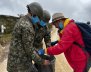 Dos militares sosteniendo una bolsa de basura 