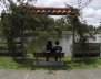 Un hombre y una mujer sentados frente al lago del Parque de los Novios 