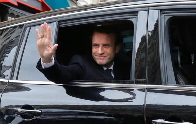 Emmanuel Macron, head of the political movement En Marche !, or Onwards !, and candidate for the 2017 presidential election, waves from his car as he leaves his home during the second round of the election, in Paris