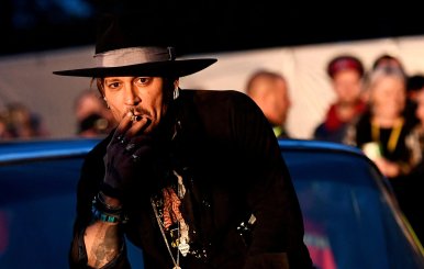 FILE PHOTO: Actor Johnny Depp poses on a Cadillac at Worthy Farm in Somerset during the Glastonbury Festival