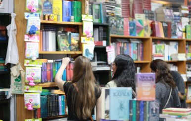 Dos mujeres mirando libros en una estantería 