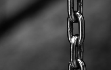 Cadena gris colgando sobre un fondo oscuro