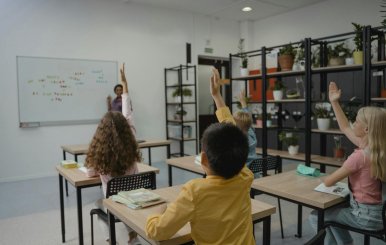 Niños en una salón de clase participando activamente 