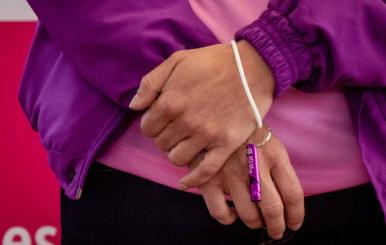 Mujer que sostiene en sus manos un silbato color morado