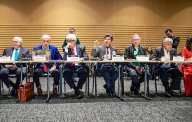Claudia López sentada en una mesa junto con su gabinete
